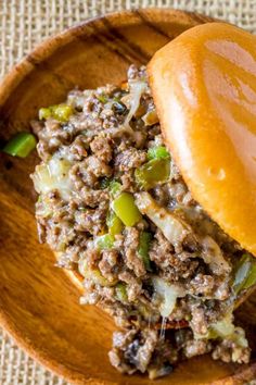 a close up of a hamburger on a wooden plate