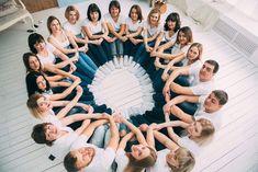 a group of people sitting in the middle of a circle with their hands on each other