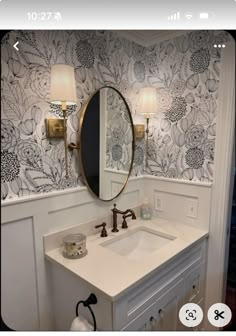 a white sink sitting under a bathroom mirror next to a wall mounted faucet