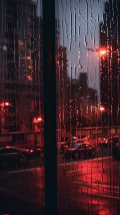 rain drops on the window as cars drive by at night