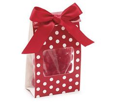 a red and white polka dot gift bag filled with lollipops in it