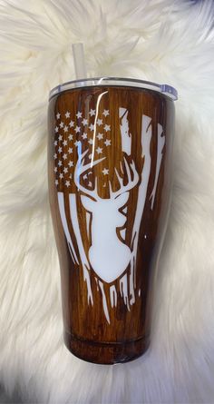 a wooden tumbler with an image of a deer and american flag painted on it