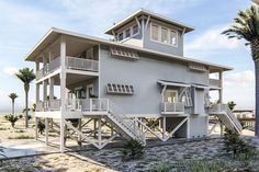 a two story house on the beach with palm trees