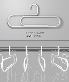 there are several clothes hangers on the rack in front of an advertisement for clip hanger