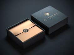 an open black box with a gold tie in it on a dark surface next to the packaging