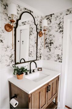 a bathroom with floral wallpaper and wooden vanity