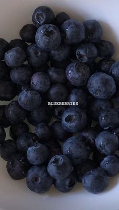 blueberries in a white bowl with the words blueberries written on top of them