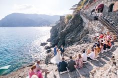 a bride and groom are walking down the stairs to their wedding ceremony on the beach