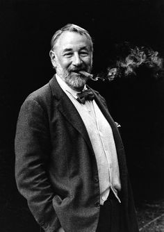 an old photo of a man with a pipe in his mouth and wearing a suit