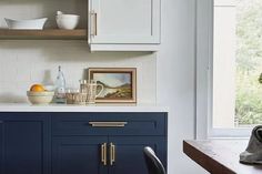 a kitchen with blue cabinets and white counter tops