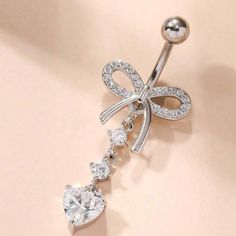 a close up of a diamond and bow belly ring