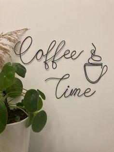 a sign that says coffee and time next to a potted plant