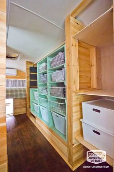 the inside of a small storage room with baskets and bins on each shelf in it