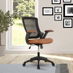 an office chair sitting in front of a window with pictures on the wall behind it