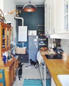 a kitchen filled with lots of clutter and wooden counter top next to a refrigerator