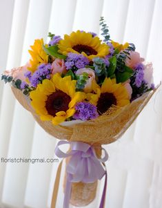 a bouquet of sunflowers and other flowers is tied to a burlock