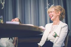 an older woman sitting at a table smiling