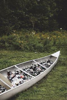 a canoe filled with assorted items sitting in the grass