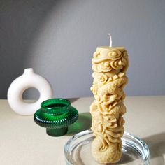 a candle that is sitting on a glass plate next to some other items in the background