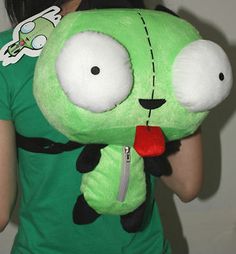 a woman in a green shirt is holding a stuffed animal with big eyes and nose