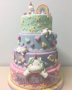 there is a three layer cake with unicorns on it