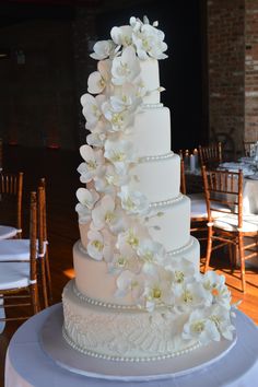 a wedding cake with white flowers and pearls