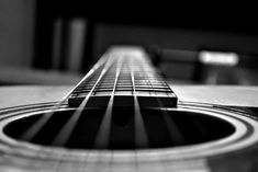 an acoustic guitar is shown in black and white, with the fret section visible