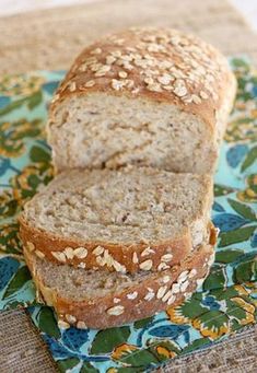 two loaves of bread sitting on top of a blue and green place mat with flowers