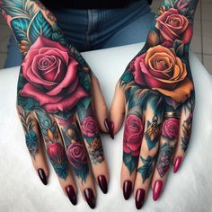 a woman's hands with tattoos and flowers on them