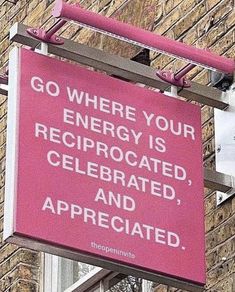 a pink sign hanging from the side of a brick building that says go where your energy is celebrated, and appreciated