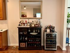 there is a small bar in the corner of this room with many bottles on it