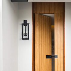 a wooden door with two lights on the side and a light hanging from the ceiling