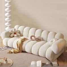 a white couch sitting on top of a carpeted floor next to a table and vases