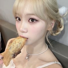 a woman with blond hair eating a cookie