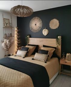 a bedroom with green walls and wooden headboard, two hanging lights above the bed