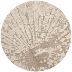 a round rug with an abstract design on the top and bottom, in neutral tones