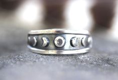 "This listing is for one sterling silver moon phase celestial stacking ring. Wear solo or with stacking bands for an irresistibly enchanting and boho set. I make these with 18 gauge sheet metal pushed into a steel die in my hydraulic press- pushing the metal into the design so it is three dimensional with the moon phases and border raised out. This is then sawed out and fired onto sturdy 10 gauge sterling silver half round wire. This is a substantial ring, not flimsy. Makes a great gift for any Silver Midi Rings With Moon Phase, Silver Open Ring With Moon Phase, Silver Moon Phase Crystal Ring, Silver Mystical Moon Phase Ring, Silver Rings With Moon Phase, Moon Phase Ring, Witch Rings, Affordable Rings, Celestial Ring