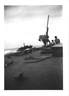 black and white photograph of people on the deck of a ship looking out to sea