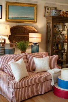 a living room with striped couches and pictures on the wall above them, along with other furniture