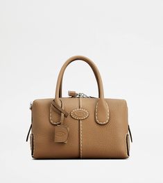 The timeless elegance of the Di Bag style is declined in a mini bauletto version, with a double-slider zip and padlock. Crafted in soft calfskin leather, with stitching on the trims, it features two tubular handles, a removable shoulder strap and the distinctive Tod's logo stamped on the front. Complemented by a removable internal pouch, it accompanies with class and femininity your everyday outfit. Tods Hobo Bag, Tods Handbags, On-the-go Cotton Bags With Leather Trim, On-the-go Bag With Top Handle And Leather Trim, Tods Timeless Bag, Trainers Women, Gift Boutique, Leather Bags Handmade, Logo Stamp