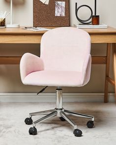 a pink office chair sits in front of a desk with a cork board on it