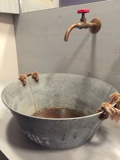 a metal bucket filled with water next to a faucet