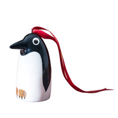 a ceramic penguin ornament with a red ribbon