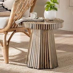 a wicker chair and table in a living room with a potted plant on top