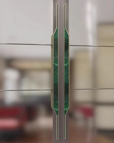 a green clock sitting on the side of a glass wall