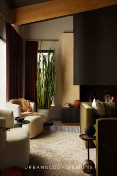 a living room filled with furniture and a fire place next to a tall plant in the corner