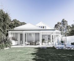 a white house sitting on top of a lush green field