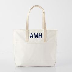 a white tote bag with the word amh on it's front pocket