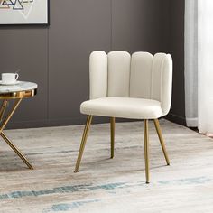 two white chairs sitting next to each other on top of a carpeted floor in front of a painting