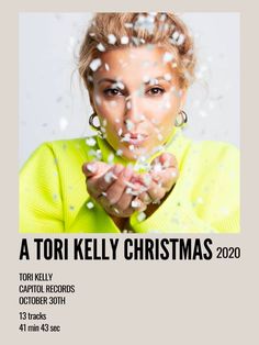 a woman blowing confetti on her face with the words tori kelly christmas 2020